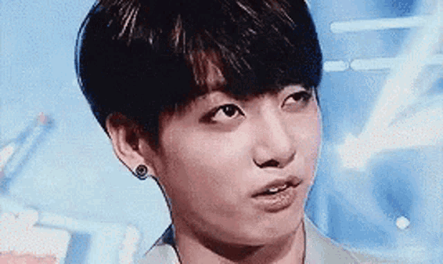 a close up of a young man making a funny face with his mouth open .