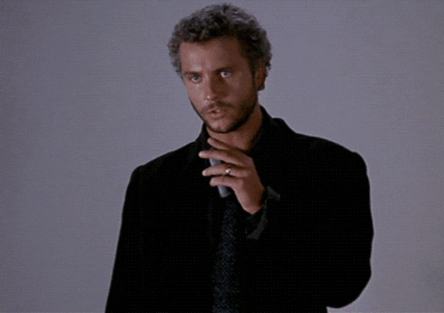 a man in a suit and tie is holding a microphone and says " this is my design "