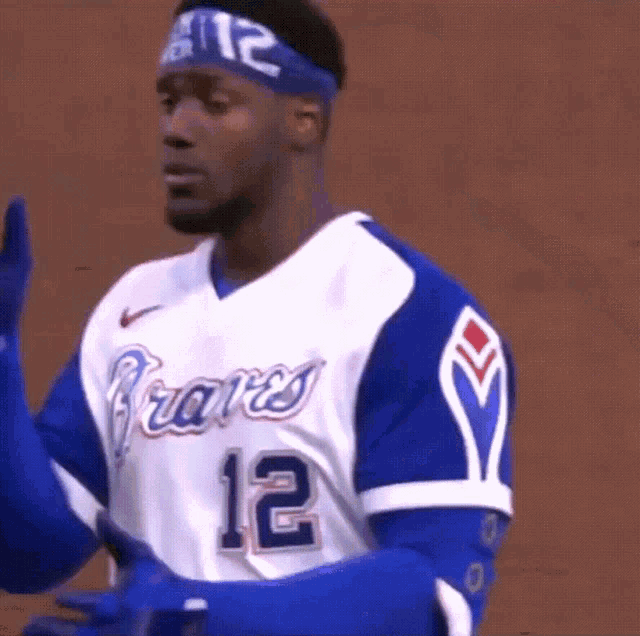 a man wearing a braves jersey and gloves