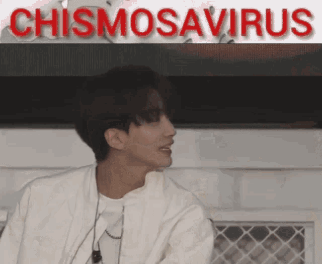 a man in a white jacket stands in front of a sign that says chismosaurus