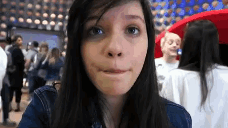 a girl making a funny face in front of a crowd of people