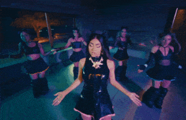 a group of anime girls are dancing in a dark room with purple lights