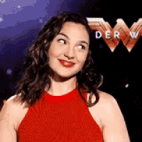 a woman in a red dress is smiling and looking up .