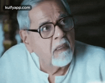 a man with a beard and glasses is making a funny face .