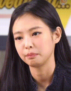 a close up of a woman 's face with long black hair making a sad face .