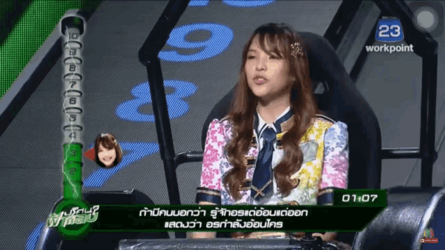 a woman is sitting in front of a screen that says 23 workpoint