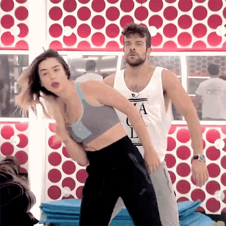a man and a woman are dancing in a gym .