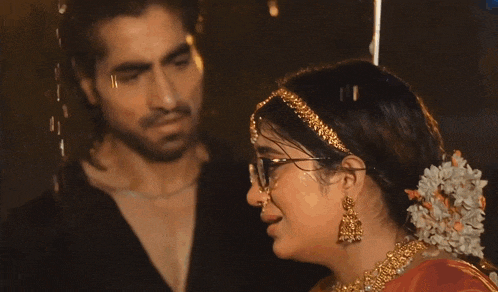 a man and a woman are standing in the rain and the woman is wearing glasses
