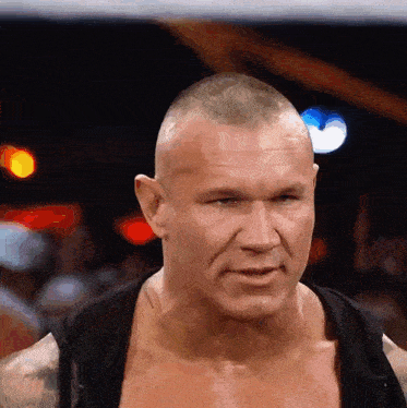 a man without a shirt is looking at the camera with a serious look on his face