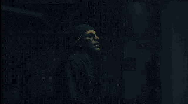 a person 's hand is visible in the dark while wearing a mask