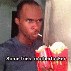 a man is smoking a cigarette while holding a bag of french fries