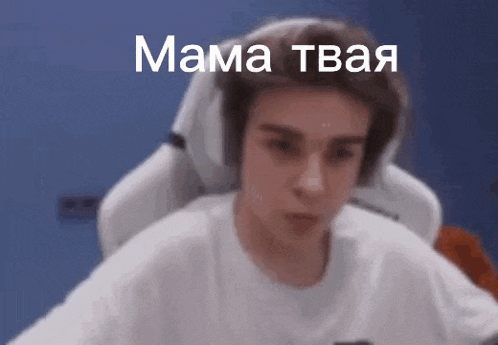 a young man wearing headphones is sitting in a chair and looking at the camera .