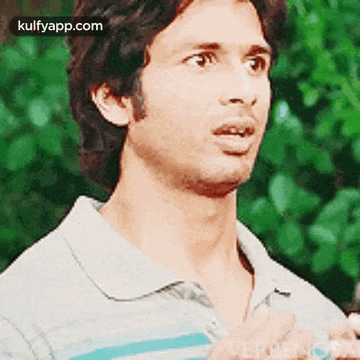 a man with a surprised look on his face is wearing a gray and blue striped shirt .