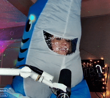 a person in a shark costume with a microphone