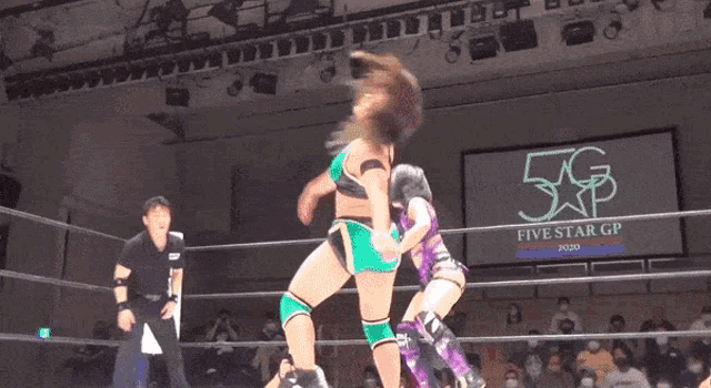 two women are wrestling in a ring with a five star gp sign in the background