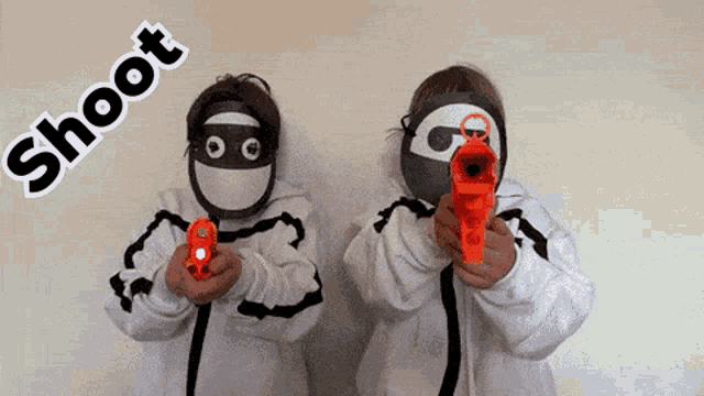 two boys wearing masks are holding toy guns and the words shoot are above them