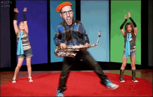 a man is playing a saxophone while two girls are dancing