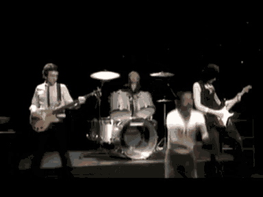 a man in a t-shirt that says ' i love you ' on it is dancing in front of a drum set
