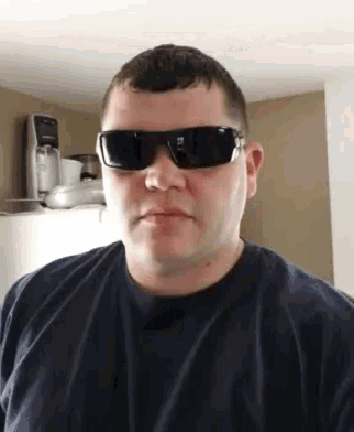 a man is wearing sunglasses and a black shirt