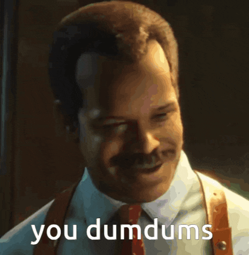 a man in a suit and tie with the words you dumdums on his face