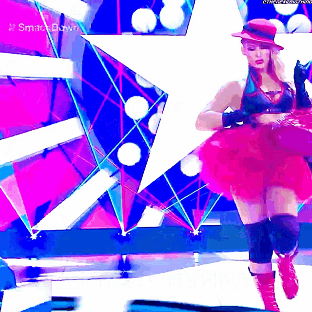 a woman in a pink tutu is on a stage with a star in the background and the words smack down on the bottom