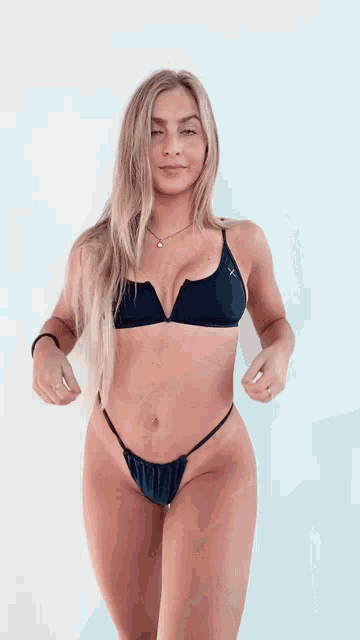 a woman in a black bikini with an x on the top