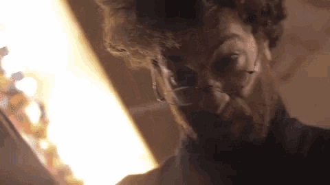 a man with glasses and a beard looks down