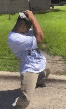 a man in a white shirt is kneeling on the ground