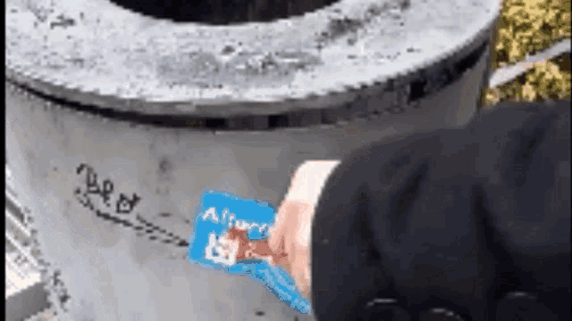 a person is putting a sticker on a concrete object that says ' afford '