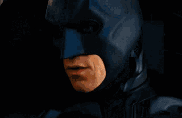 a close up of a man 's face in a batman mask