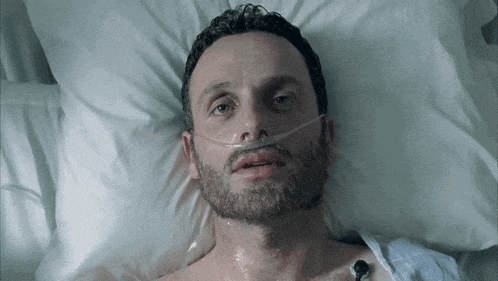 a man laying in a hospital bed with an oxygen mask on his face