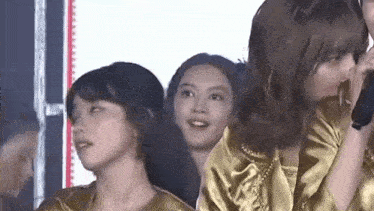a group of young women are standing next to each other in a crowd .
