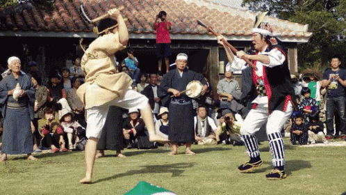 a group of people are gathered in front of a building watching a group of people perform