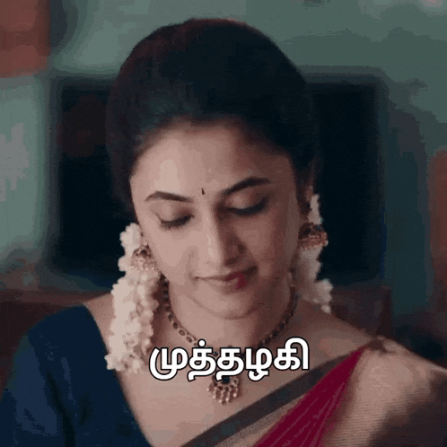 a woman wearing a necklace and earrings is smiling with a message in another language .