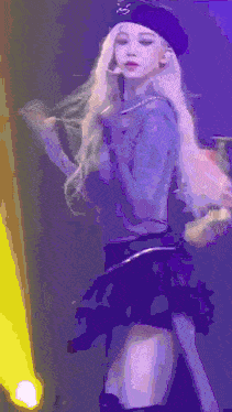 a woman with blonde hair is wearing a purple beret and a black skirt .