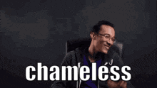 a man with glasses is sitting in a chair and smiling with the word chadless written in white letters .