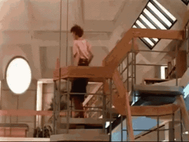 a woman is walking down a set of stairs in a building