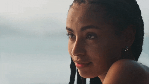 a close up of a young woman 's face with braids
