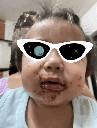 a little girl wearing sunglasses with a moon on them