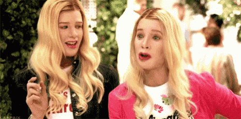 two blonde women are standing next to each other with their mouths open and making funny faces .