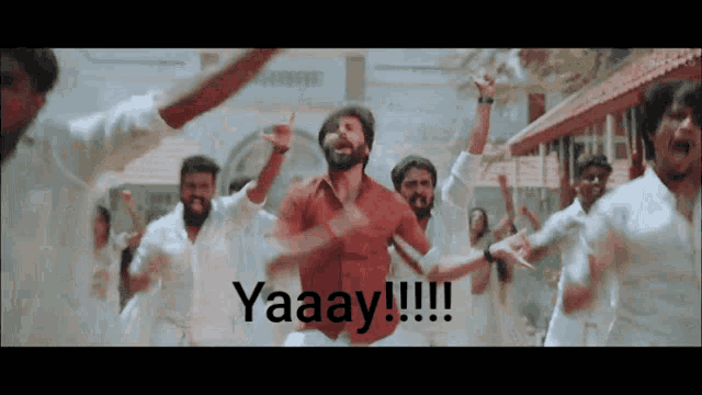 a man in a red shirt is dancing in front of a group of people with the words yaaay !!! on the bottom