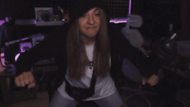 a woman in a black hat and white shirt is dancing