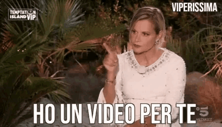a woman in a white dress is giving a middle finger while sitting in front of a palm tree .