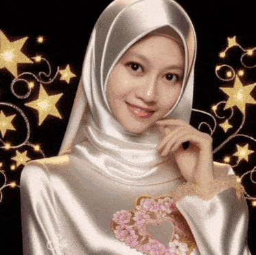 a woman wearing a white hijab with a heart embroidered on her chest