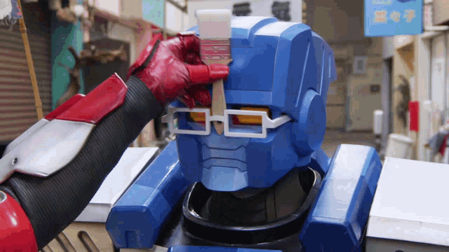a robot with glasses is being painted by a person