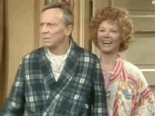 a man and a woman are standing next to each other and smiling .