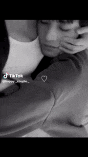 a black and white photo of a man and woman with a heart on their shirt