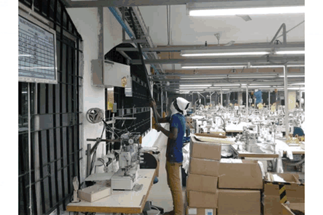 a man in a blue shirt is working in a factory