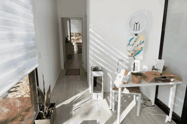 a room with a painting on the wall and a table with a plant on it
