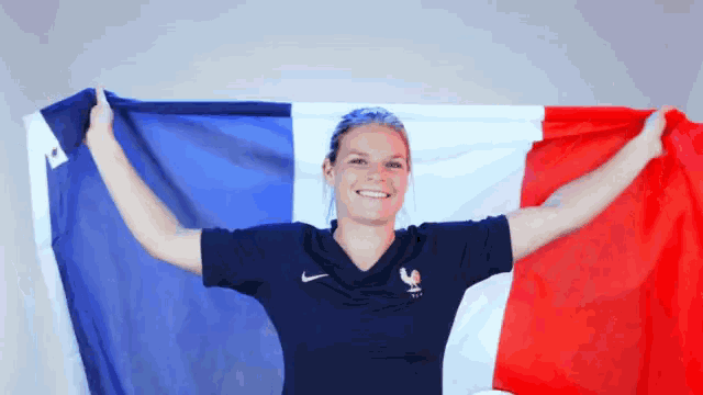 a woman in a nike shirt holds a flag